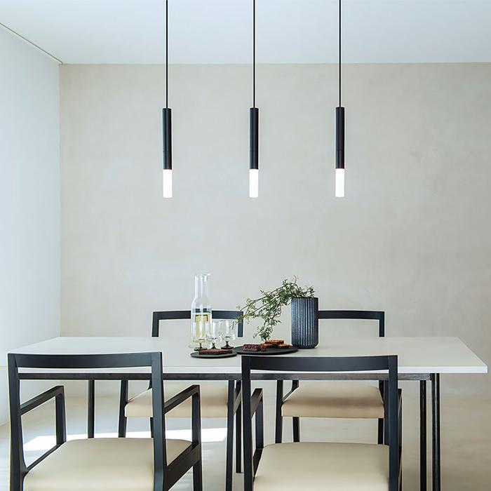 Minimal pendant lights installed above a contemporary dining table in a modern interior.