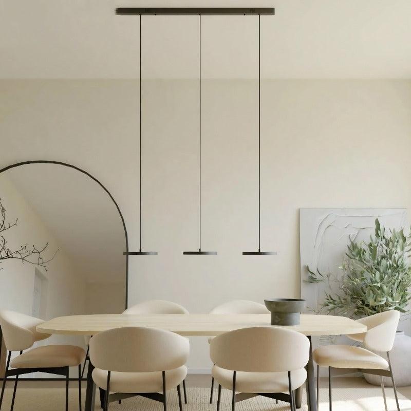 Minimal pendant lights installed above a contemporary dining table in a modern interior.