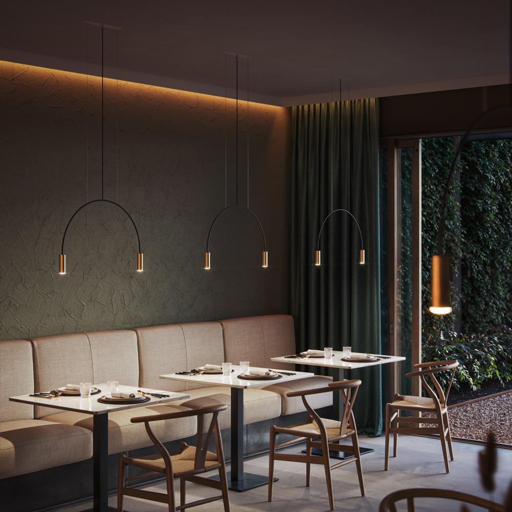 Minimal pendant lights installed above a contemporary dining table in a modern interior.
