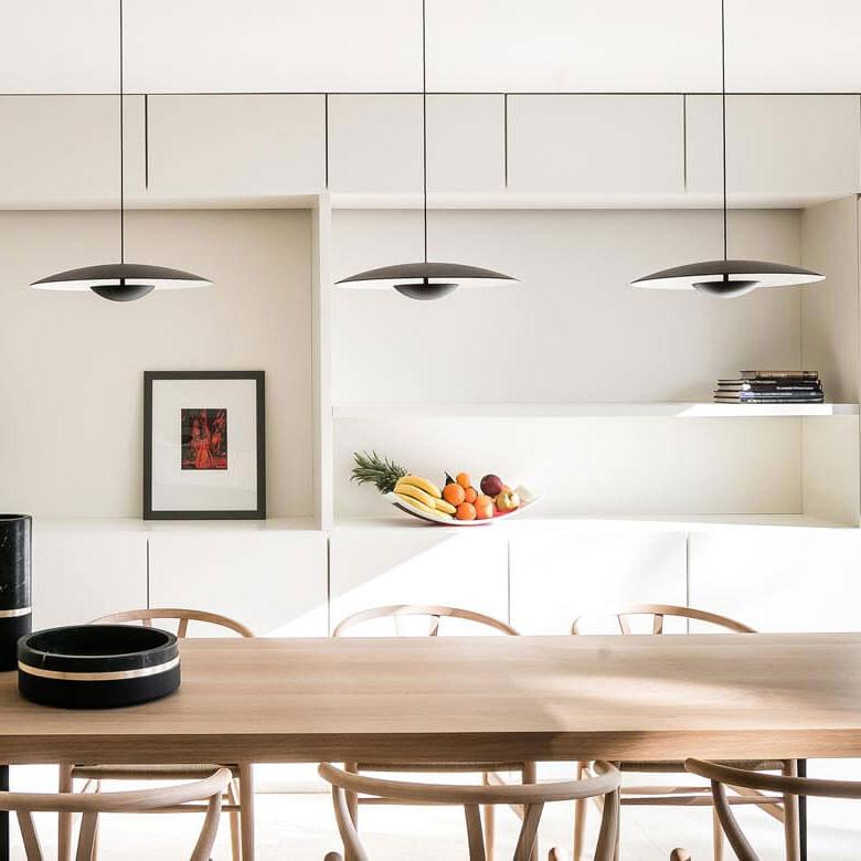 Minimal pendant lights installed above a contemporary dining table in a modern interior.