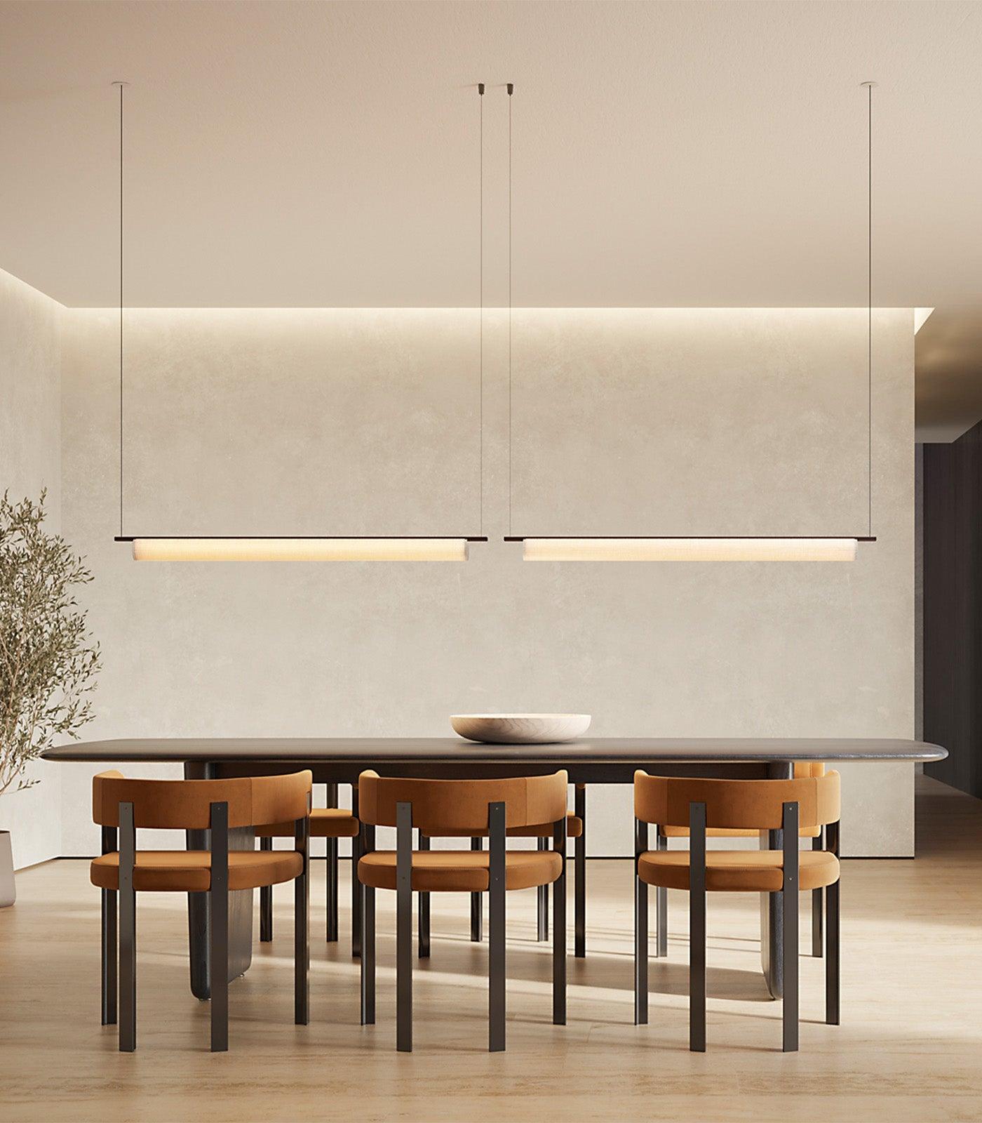 Minimal chandelier installed above a contemporary dining area in a premium architectural interior.