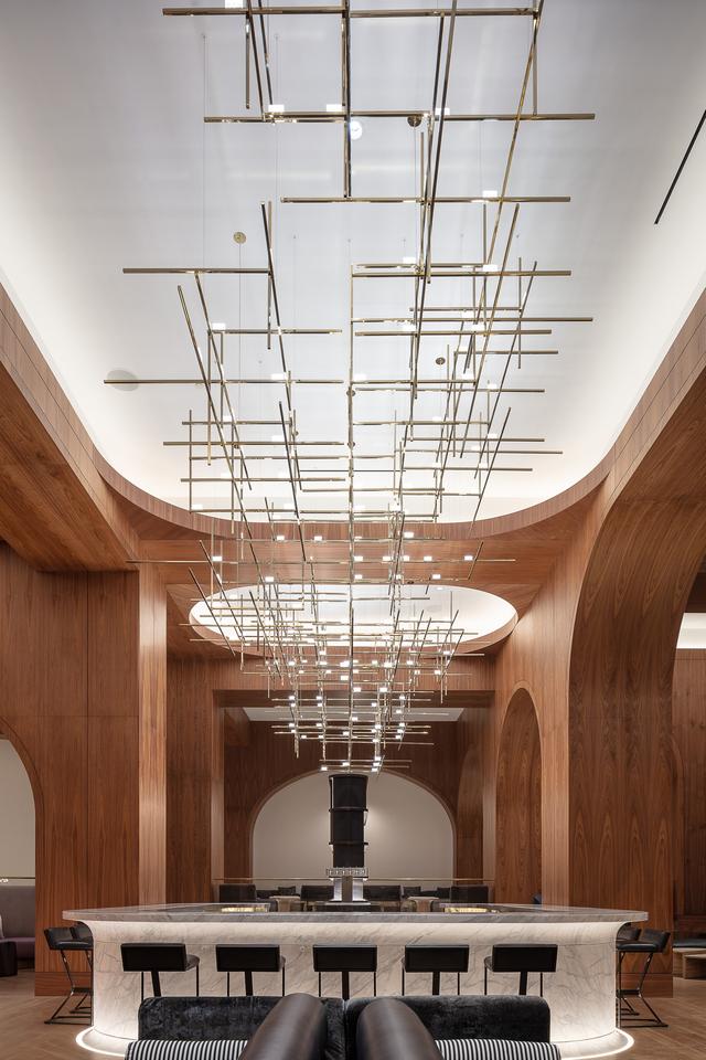 Minimal chandelier installed above a contemporary dining area in a premium architectural interior.