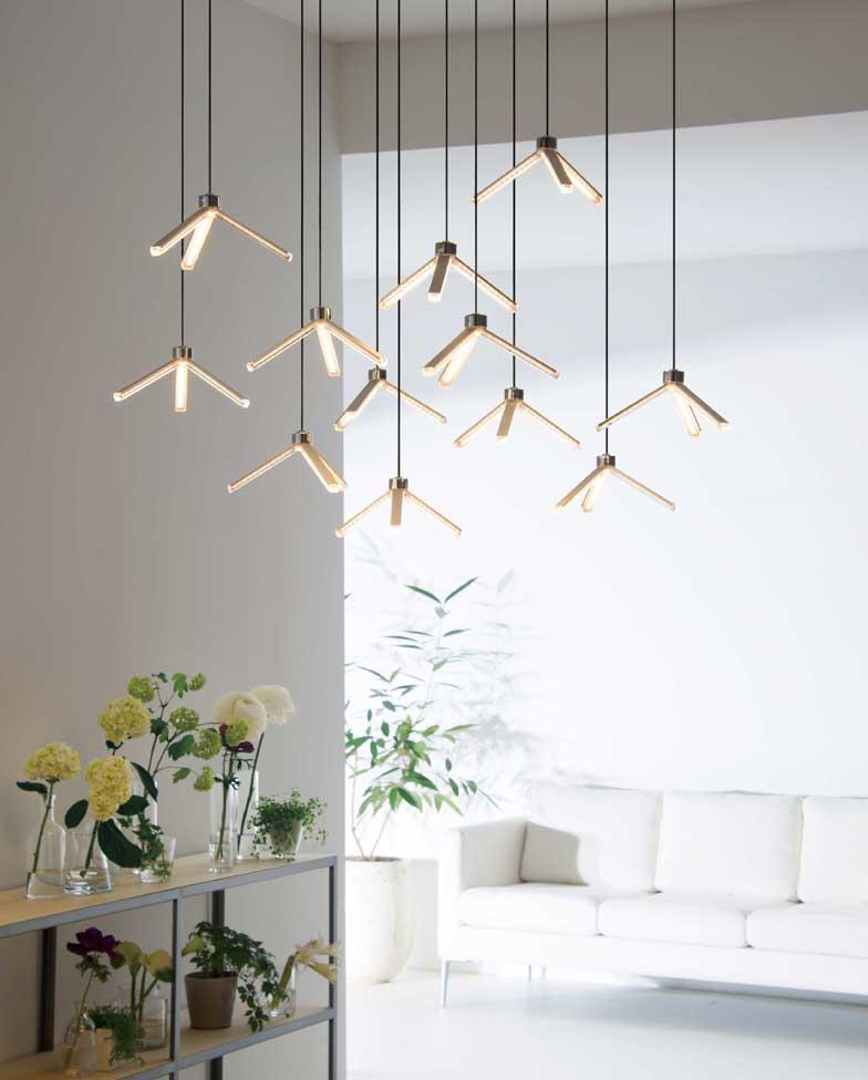 Minimal chandelier installed above a contemporary dining area in a premium architectural interior.