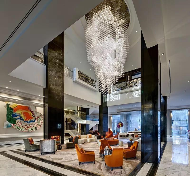 Crystal chandelier installed in a luxury hotel lobby with premium architectural design.